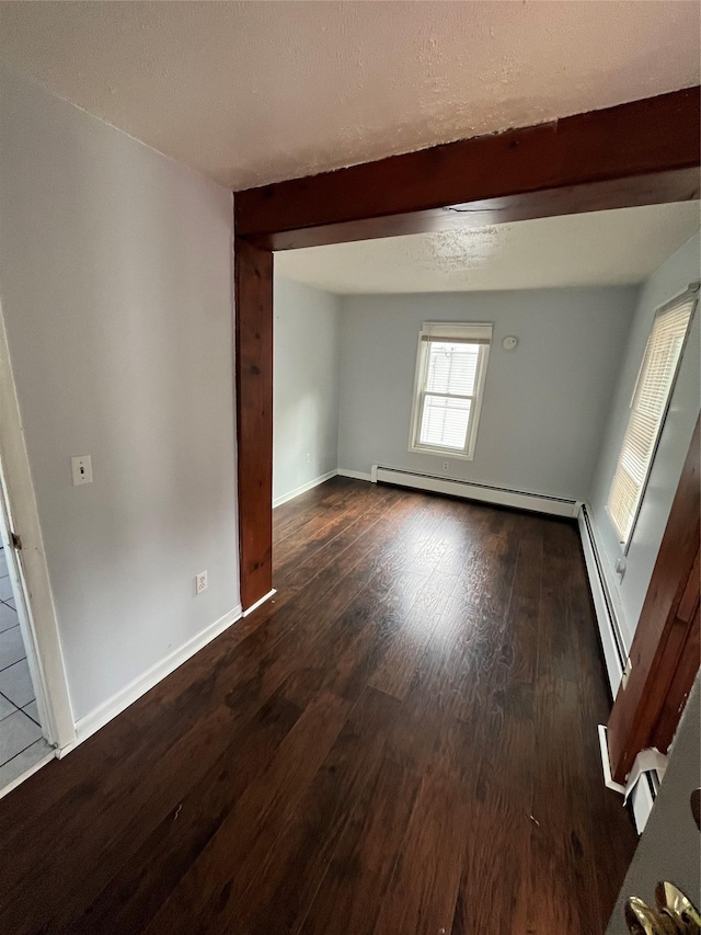 unfurnished room featuring baseboards, beam ceiling, dark wood-style flooring, a textured ceiling, and a baseboard heating unit