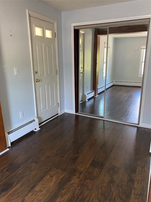 entryway with baseboard heating, baseboards, and wood-type flooring