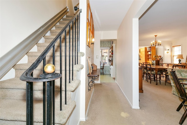 interior space with baseboards, carpet floors, and a chandelier