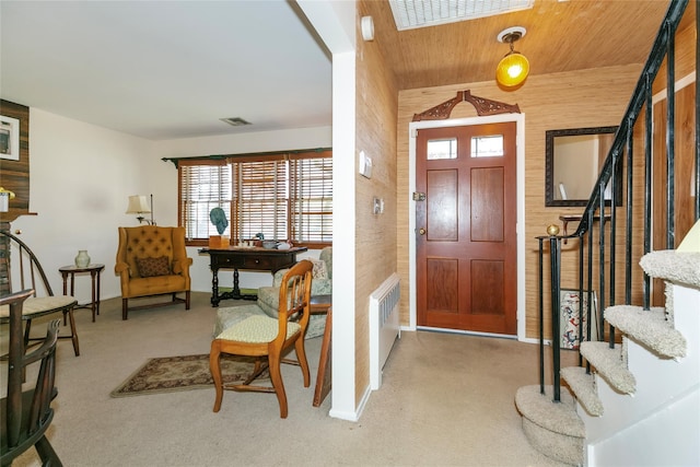 carpeted entryway featuring visible vents and stairs