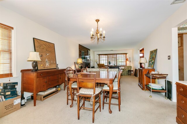 dining space with light colored carpet and an inviting chandelier