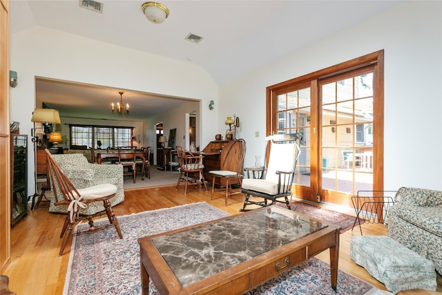 sitting room with an inviting chandelier, vaulted ceiling, visible vents, and light wood-type flooring