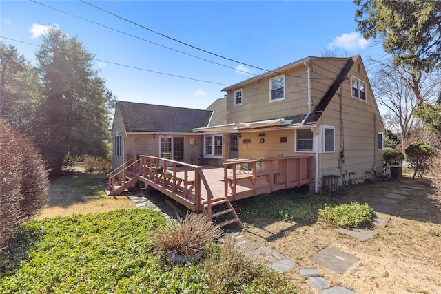 back of property featuring a deck, central air condition unit, and a shingled roof