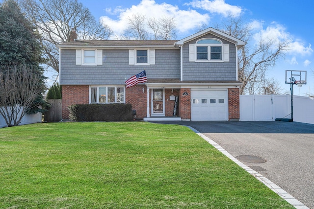 view of front of home with a front lawn, aphalt driveway, fence, an attached garage, and brick siding