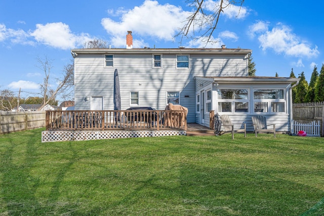 rear view of house with a wooden deck, a lawn, a chimney, and fence