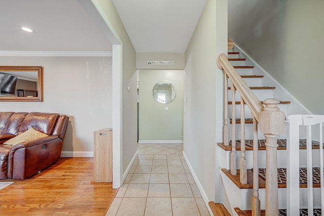 corridor with light tile patterned floors, baseboards, recessed lighting, ornamental molding, and stairs