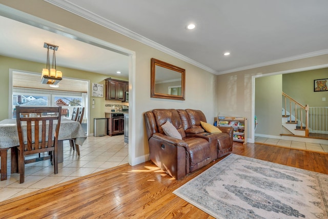 living area with stairway, light wood-style flooring, and ornamental molding