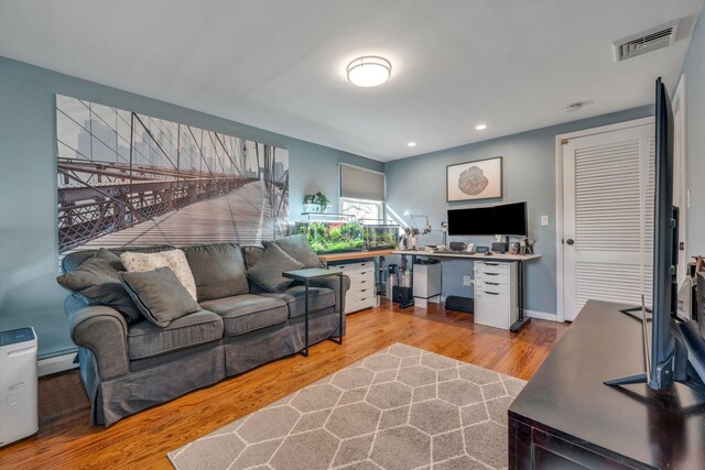 living room featuring recessed lighting, visible vents, wood finished floors, and a baseboard radiator