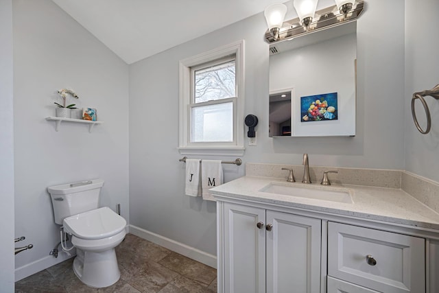 bathroom with vanity, toilet, and baseboards