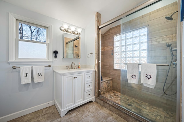 bathroom featuring baseboards and a shower stall