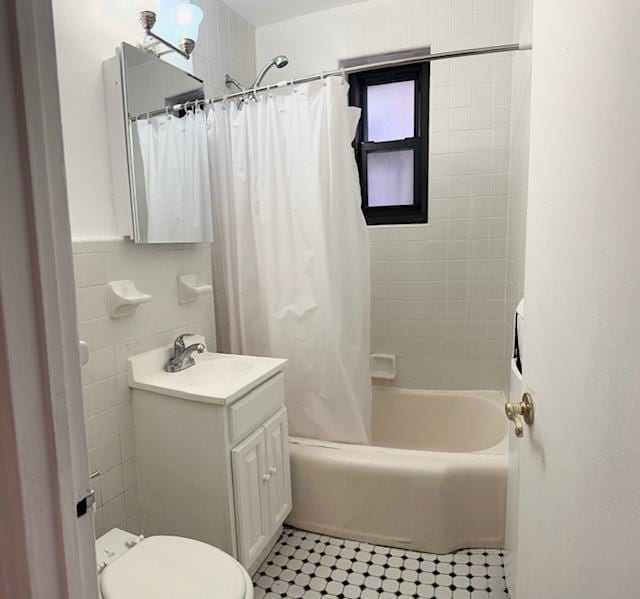 bathroom featuring toilet, tile walls, vanity, and shower / bath combo