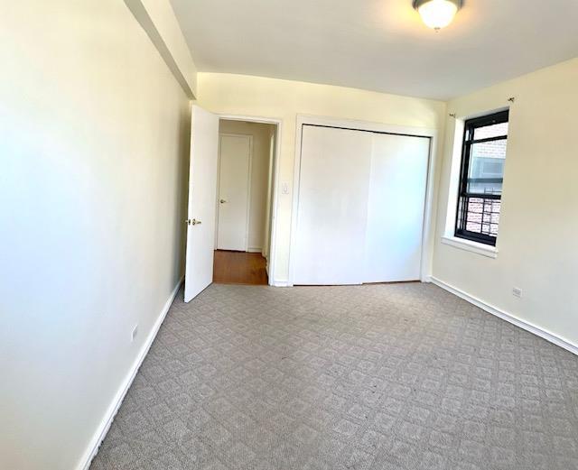 unfurnished bedroom featuring a closet, carpet, and baseboards