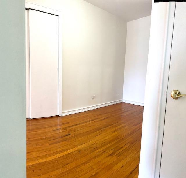 empty room with baseboards and hardwood / wood-style flooring