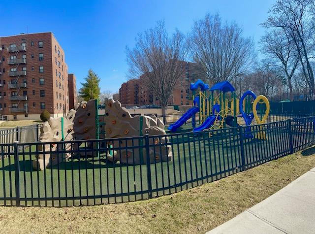 community jungle gym with a lawn and fence