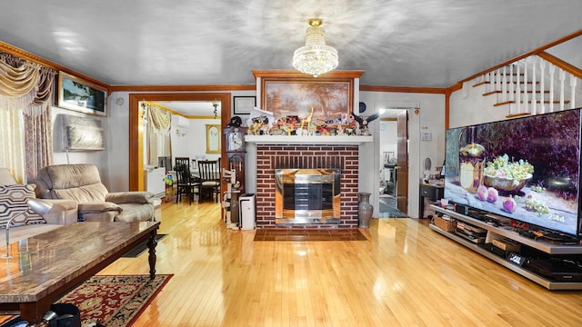 living area with a fireplace, stairs, crown molding, and hardwood / wood-style flooring