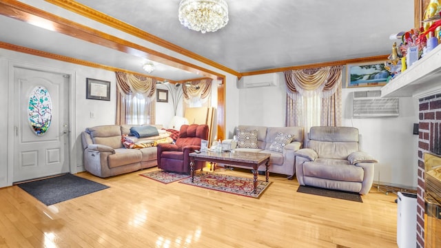 living area with a chandelier, a wall mounted AC, wood-type flooring, and ornamental molding