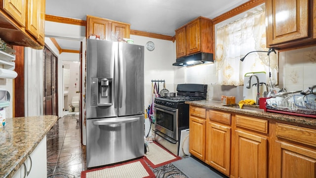 kitchen with under cabinet range hood, stainless steel appliances, tasteful backsplash, and a sink