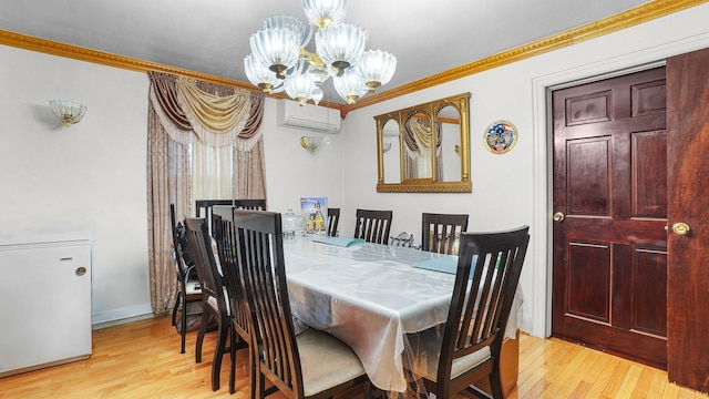 dining room with an AC wall unit, light wood-style floors, an inviting chandelier, and crown molding