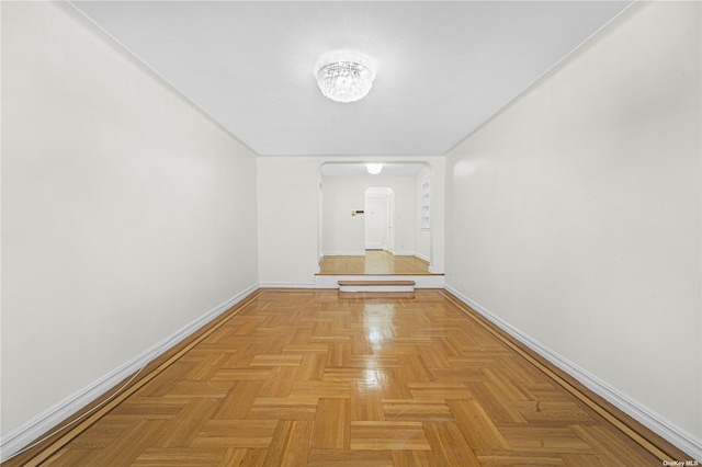 hallway with baseboards and arched walkways