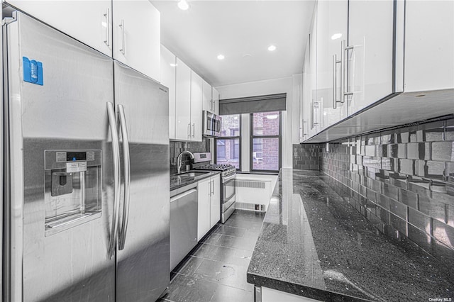 kitchen featuring white cabinets, modern cabinets, backsplash, and stainless steel appliances