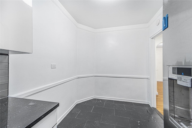 interior space with crown molding and arched walkways