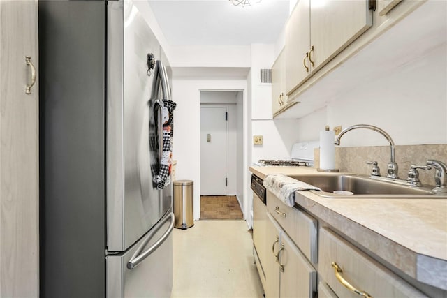 kitchen with visible vents, dishwasher, light countertops, freestanding refrigerator, and a sink