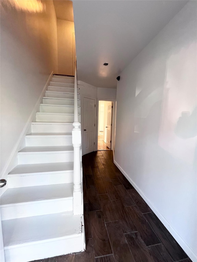 stairs featuring baseboards and wood tiled floor