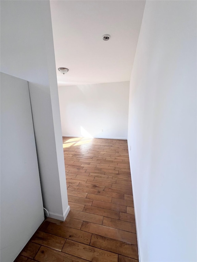 hallway with baseboards and hardwood / wood-style floors