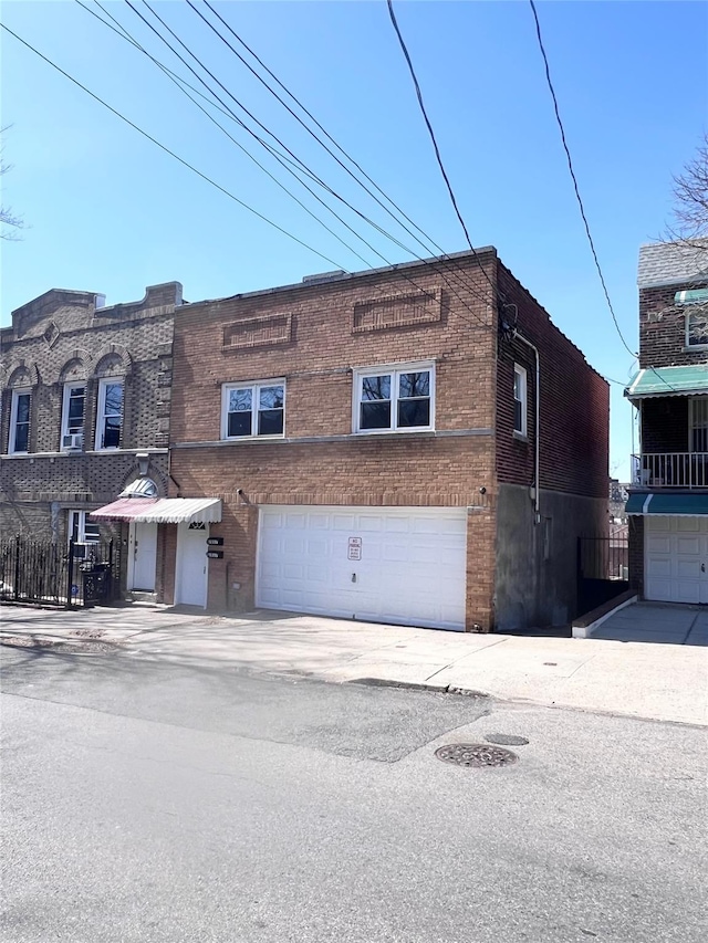 multi unit property with an attached garage and brick siding