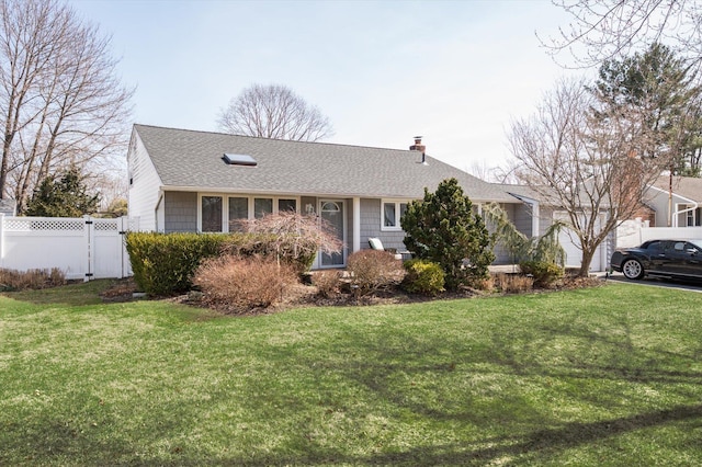 ranch-style house featuring a gate, a shingled roof, a front lawn, and fence