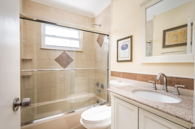 bathroom featuring vanity, toilet, combined bath / shower with glass door, and ornamental molding