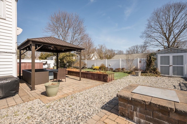 view of patio featuring a gazebo, a fenced backyard, a storage unit, and an outdoor structure