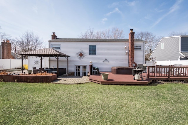 rear view of house featuring a gazebo, a lawn, a chimney, and fence