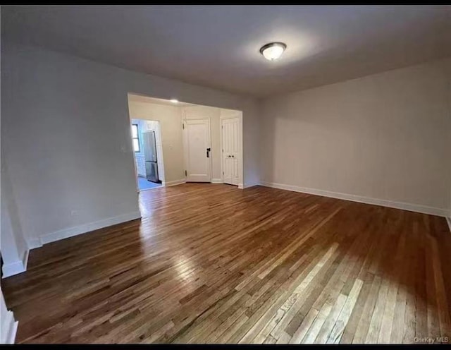 unfurnished room featuring baseboards and wood-type flooring