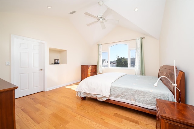 bedroom with baseboards, visible vents, lofted ceiling, light wood-style flooring, and ceiling fan