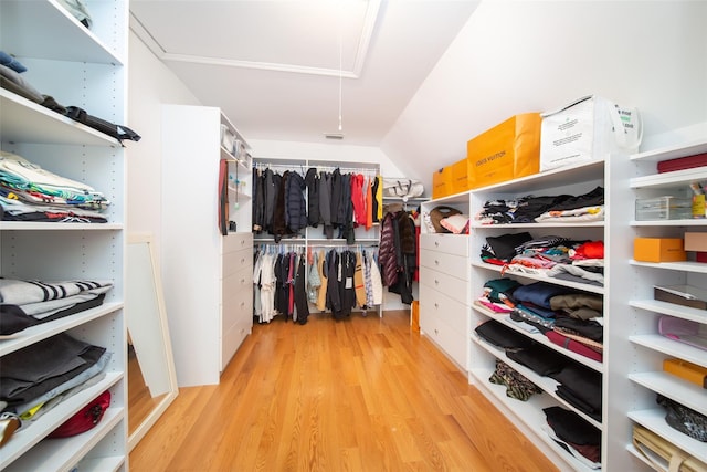 spacious closet featuring attic access, wood finished floors, and vaulted ceiling