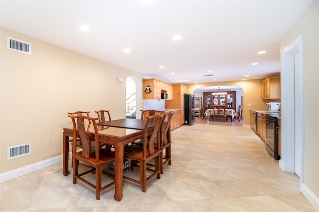 dining space with recessed lighting, visible vents, and arched walkways