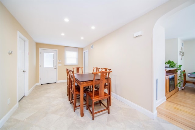 dining room featuring arched walkways, recessed lighting, and baseboards