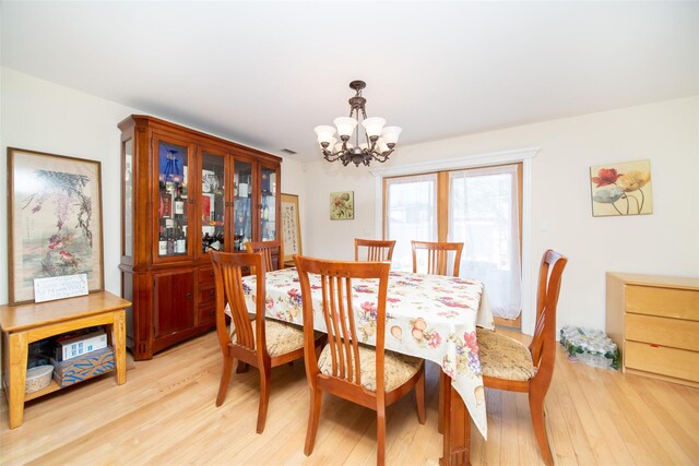 dining room with an inviting chandelier and light wood finished floors