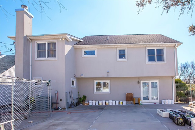 back of house with stucco siding, a patio, a chimney, and fence