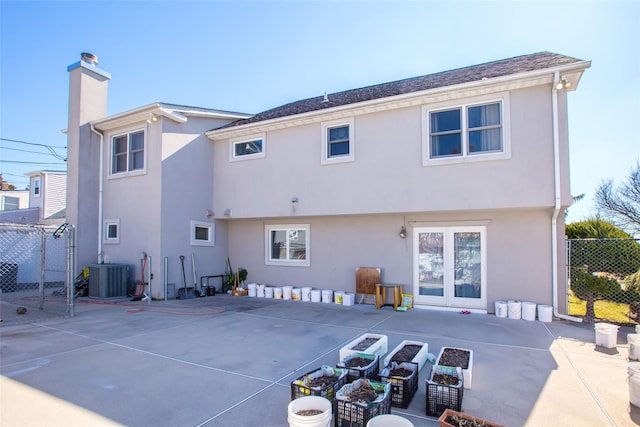 rear view of house with a patio, fence, central AC, a chimney, and stucco siding