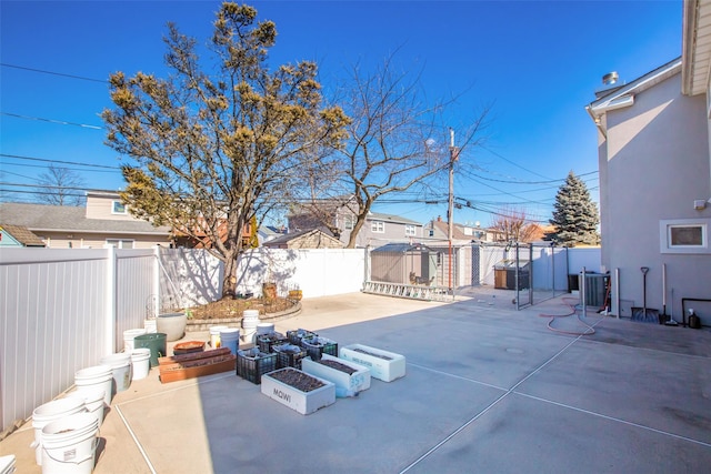 view of patio with central AC, a fenced backyard, and an outdoor fire pit