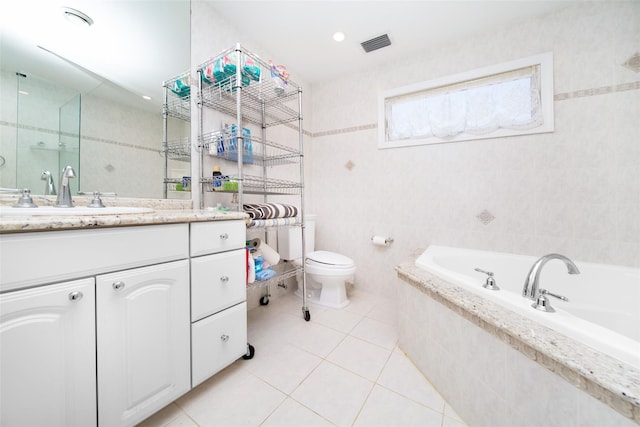 bathroom featuring tile patterned flooring, visible vents, tile walls, a bath, and vanity