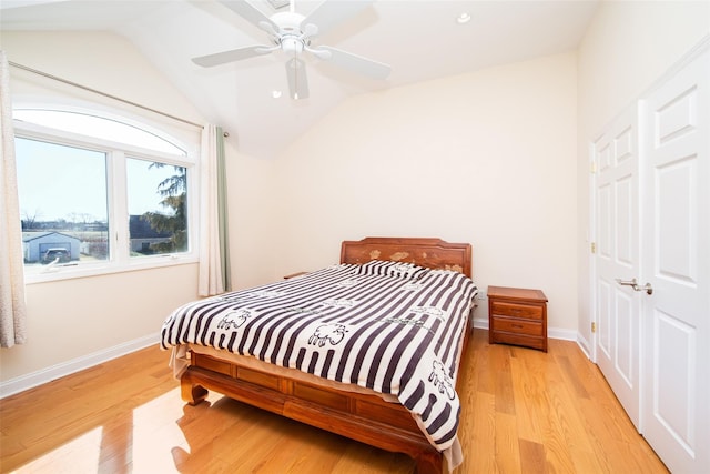 bedroom with baseboards, lofted ceiling, ceiling fan, and light wood finished floors