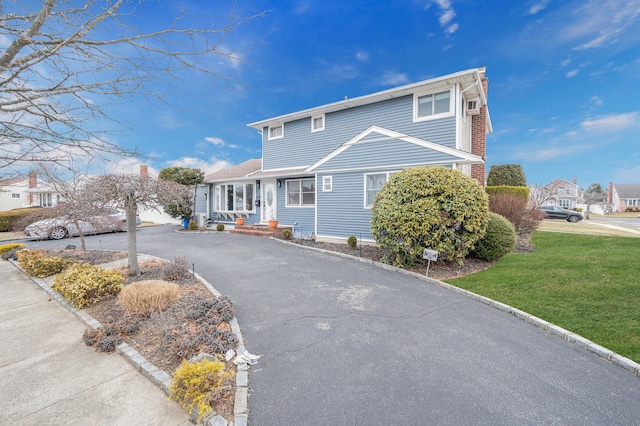 view of front facade with aphalt driveway and a front yard