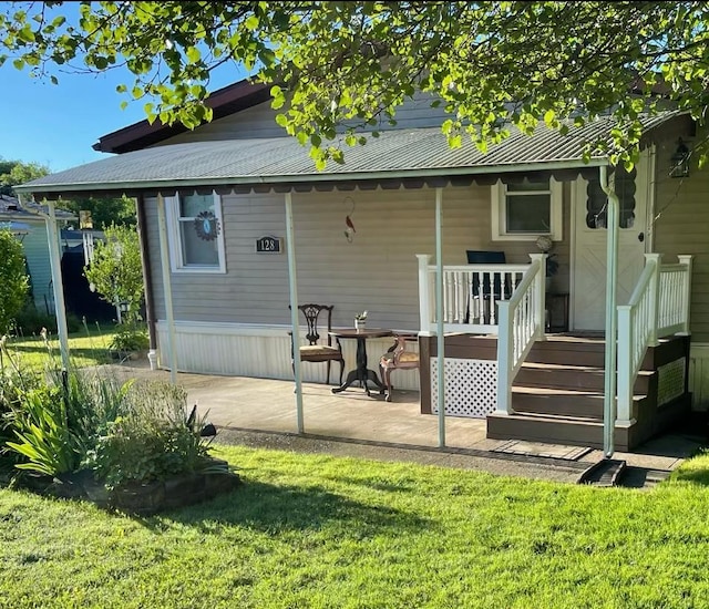 rear view of property featuring a patio and a lawn