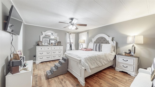 bedroom featuring a ceiling fan, light wood-style floors, and ornamental molding