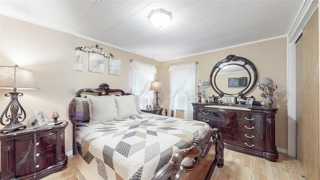 bedroom with light wood finished floors, baseboards, and ornamental molding