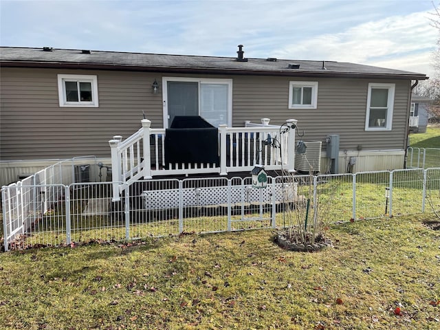 back of property featuring a yard, central AC, a wooden deck, and fence