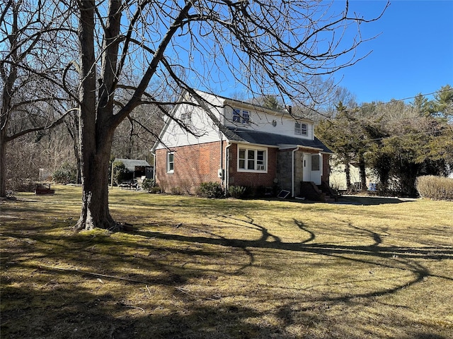 view of front of home featuring brick siding and a front yard